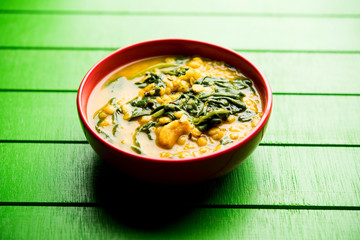 Dal Palak or Lentil spinach curry - popular Indian main course healthy recipe. served in a karahi/pan or bowl. selective focus