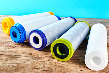 Water filters. Carbon cartridges on a wooden background. Household filtration system.
