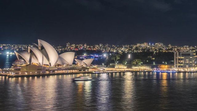Iconic Sydney Opera House at night with buzzing Sydney Harbour in timelapse video.