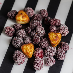 frozen blackberry with a heart-shaped cupcake on a striped striped background