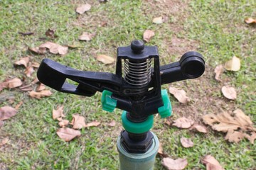 Black and Green watering sprinkler in the garden