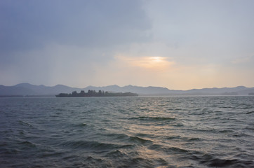 Naklejka na ściany i meble View of islands and hills over West Lake in Hangzhou, China, at sunset