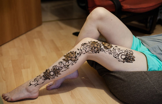 female leg with arabic or indian mehendi. Lotus flowers and beads. Beauty and fashion concept. traditional patterns or henna in Russian style