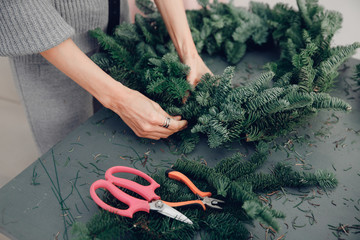 Christmas tree wreath decoration with woman hand workshop DIY © Parilov