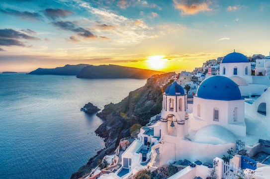 Beautiful view of Churches in Oia village, Santorini island in Greece at sunset, with dramatic sky. © Funny Studio