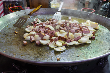 Tourism at Budapest annual christmas market food fair. Pork with vegetables on a pan
