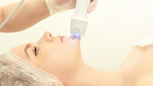 Facial micro current cosmetology procedure. Beauty technology treatment. Woman face therapy