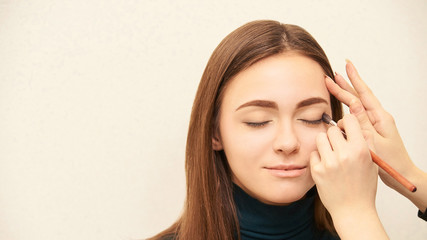 Fototapeta premium Makeup professional artist apply face mascara. Woman beauty model. Nature nude look. Contour foundation