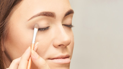 Makeup professional artist apply face mascara. Woman beauty model. Nature nude look. Contour foundation