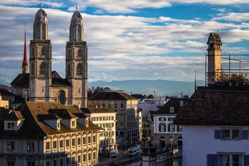Fotobehang Monument Zurich, Switzerland - view of the Grossmunster church with beautiful mountains in the background