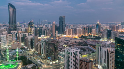 Obraz premium Modern city architecture of Abu Dhabi skyline day to night timelapse, UAE.