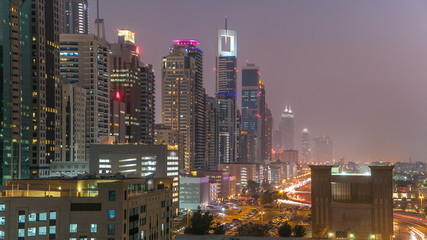 Fototapeta na wymiar Downtown Dubai towers day to night timelapse. Aerial view of Sheikh Zayed road with skyscrapers after sunset.