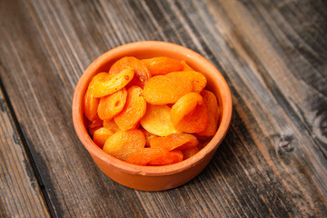 Dried apricots in a vintage ceramic bowl on a old wooden table