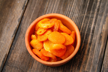Dried apricots in a vintage ceramic bowl on a old wooden table
