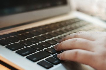 Fototapeta na wymiar image of woman hands using / typing on laptop computer selected focus on keyboard