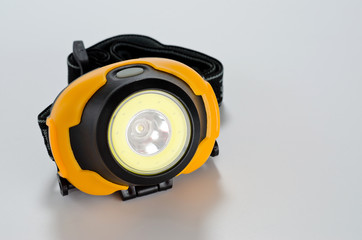 Plastic LED head flashlight black yellow on a white background