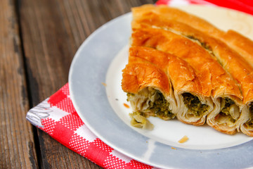 Pastry with cheese and spinach and red dish towel on an retro style wooden table