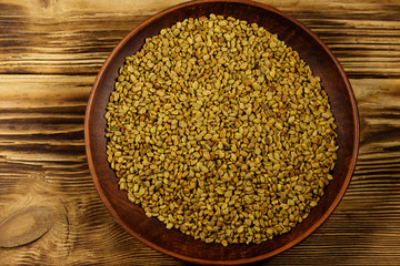 Fenugreek seeds in ceramic plate on wooden table