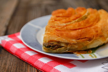 Pastry with cheese and spinach and red dish towel on an retro style wooden table