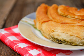 Pastry with cheese and spinach and red dish towel on an retro style wooden table
