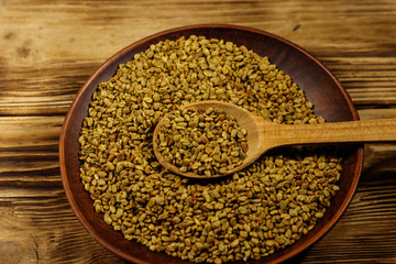 Fenugreek seeds in ceramic plate on wooden table