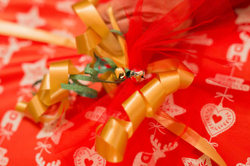 horizontal image with a close-up detail of a golden little bell used to decorate a Christmas package