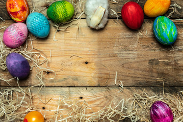 beautiful, bright, very colorful hand-painted eggs on a contrasting, raw, natural background from wooden planks