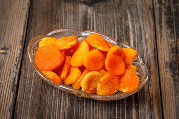 Dried apricots in a crystal bowl on a old wooden table