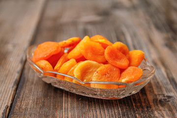Dried apricots in a crystal bowl on a old wooden table