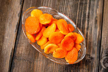 Dried apricots in a crystal bowl on a old wooden table