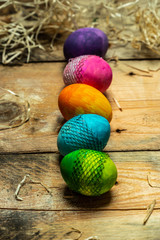 beautiful, bright, very colorful hand-painted eggs on a contrasting, raw, natural background from wooden planks