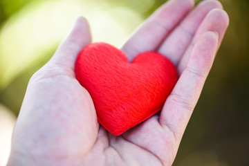 Give Love Man holding small red Heart in hands for love Valentines day Donate  Help Give love warmth take care