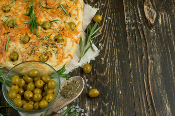 Traditional Italian focaccia with olives, rosemary and cheese - homemade flat bread flatbread. Rustic style top view. Flat-lay