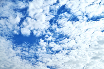 Clouds on the background of bright blue sky, summer day close-up