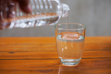 Drinking water in a glass on a wooden table