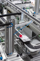 Gripper picks up the product from automated car which is on the manufacturing line in a smart factory. Industry 4.0 concept; artificial intelligence in manufacturing.