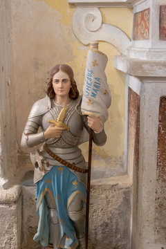 Statue de Jeanne d'Arc en tenue militaire avec son &eacute;tendard &agrave; genoux &eacute;glise de Luc&eacute;ram, Provence, France