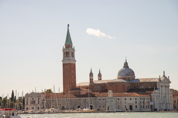 Fototapeta na wymiar Venice, Italy, island of San Giorgio Maggiore. View from the lagoon of the church of San Giorgio, the marina with sailboats and the lighthouse.