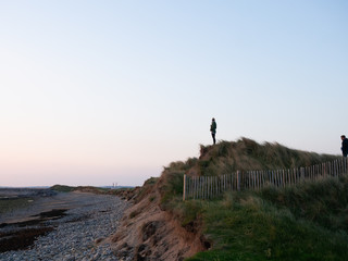 Junge Frau genießt die Aussicht am Strand von Strandhill bei Sonnenuntergang im County Sligo am Wild Atlantic Highway in Irland