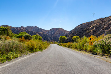 A road through the Californian desert, with a blue sky overhead
