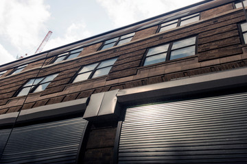 Reflection of a building and roller shutter door on a bus in Manhattan, NYC