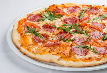 Pizza with salami and bell peppers. On a white background