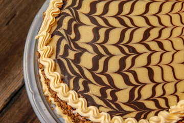 Cake with walnuts and hazelnuts from a market with plastic base on old wooden table