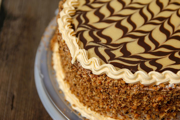 Cake with walnuts and hazelnuts from a market with plastic base on old wooden table