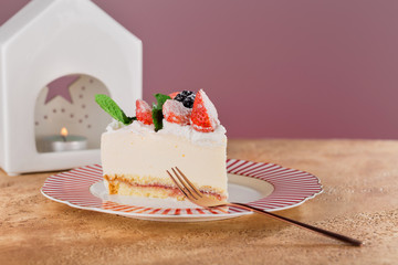 piece of cottage cheese cake with strawberries, blackberries and mint on a beautiful festive plate.