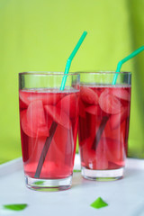 in two glass glasses poured pink fresh drink (compote, lemonade, cocktail, juice). a complementary color