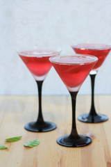 in three glass glasses for Martini poured pink fresh drink (compote, lemonade, cocktail, juice)