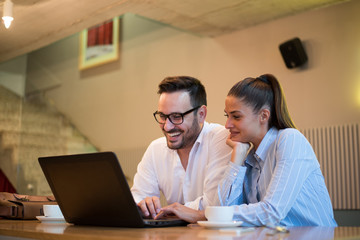 Fototapeta premium Young beautiful successful business people working together in the office looking at laptop.