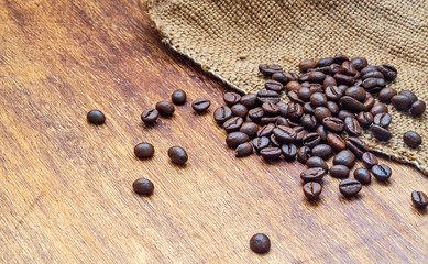 Coffee beans on wood and sackcloth background, macro, copy space