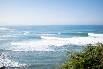 Surfer auf Welle in Panorama von Lafitenia bei Guethary im Baskenland
